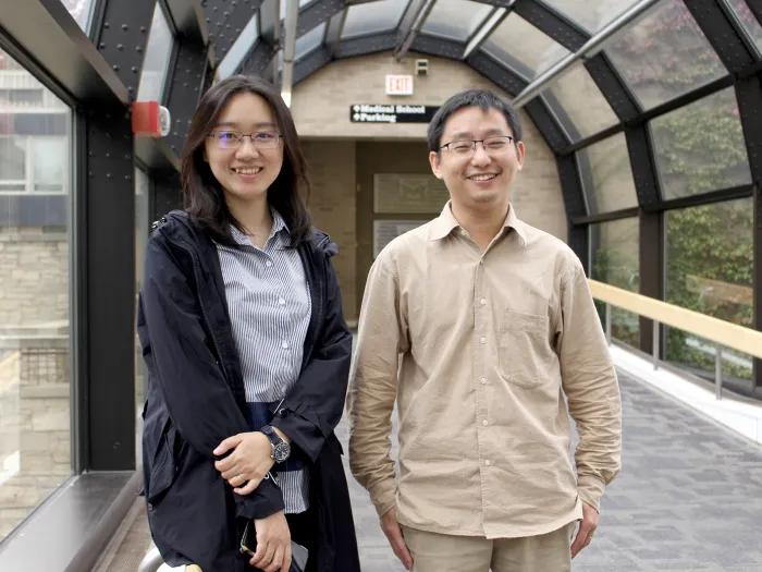 A man and a woman standing next to each other under a glass archway