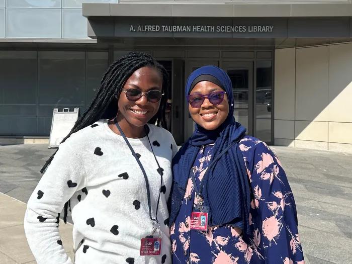 Two women wearing sunglasses standing together for a photo