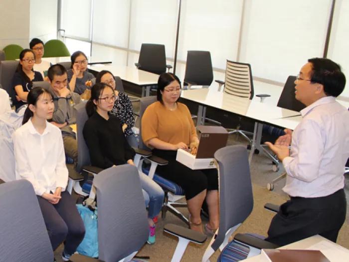 A group of people in a classroom listening to a lecture