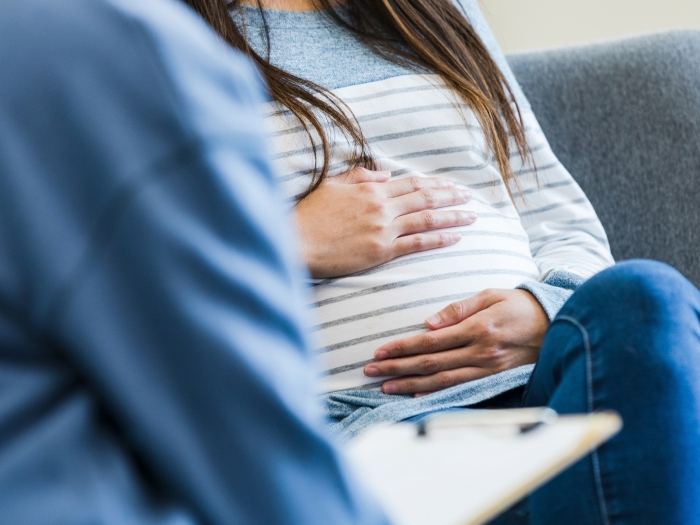 woman holding baby stomach sitting blue and white clothing