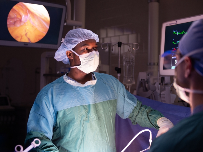 Male surgeon in surgical scrubs operating