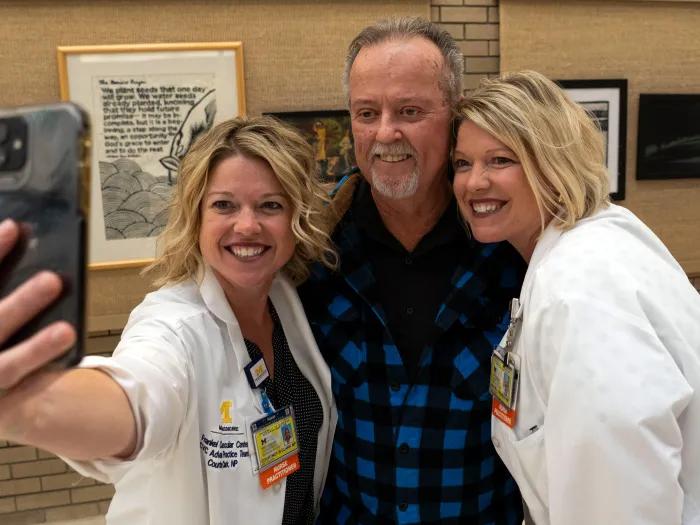taking a selfie man with two women in white coats