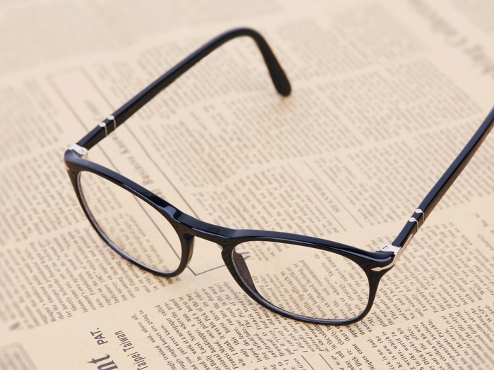 glasses on newspaper text