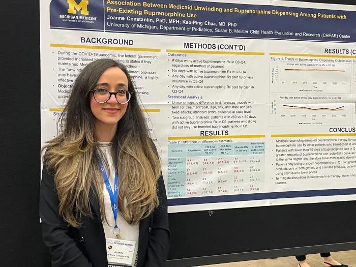 Joanne standing in front of a research poster she created