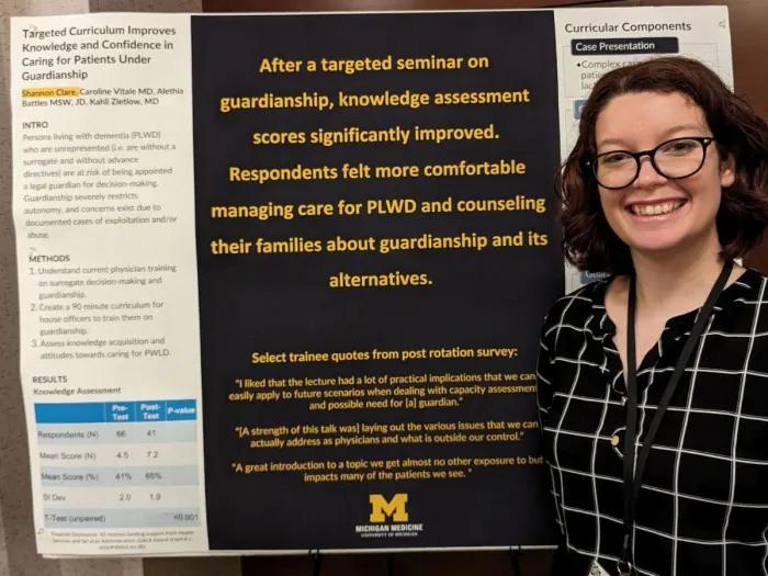 Shannon Clare stands next to a research poster