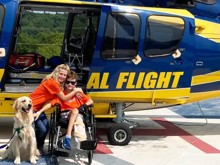 mom and son and dog in front of the survival flight helicopter