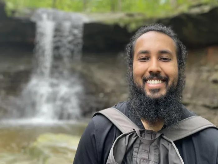 Jasdeep Kler stands in front of a waterfall