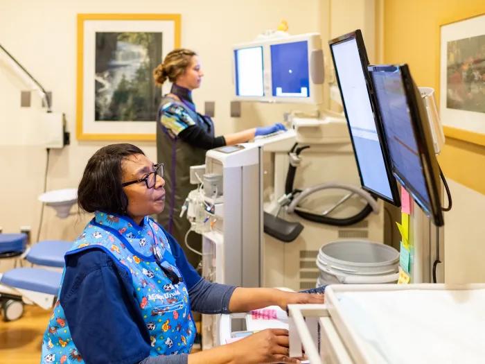 Female provider looks at computer screen at hospital