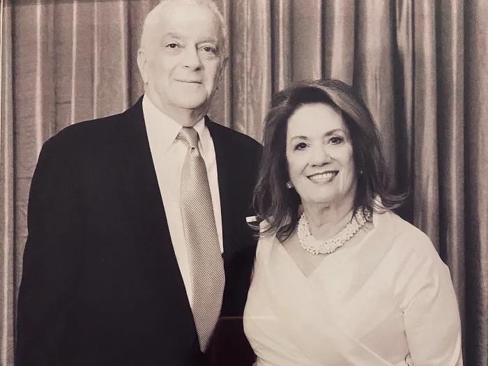 Smiling portrait of Philip and Myrna Fischer standing together in a formal setting.
