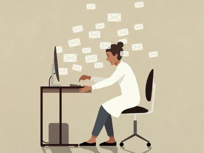 doctor at desk computer stressed and emails floating all in the air