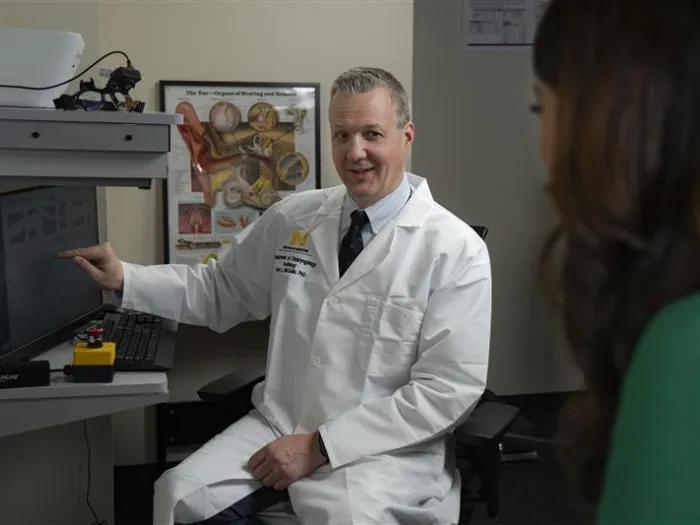 Dr. McCaslin talking to someone and pointing at a screen in a clinic
