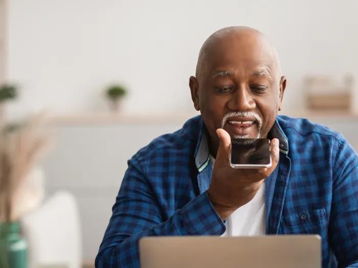 man speaking on phone while on computer