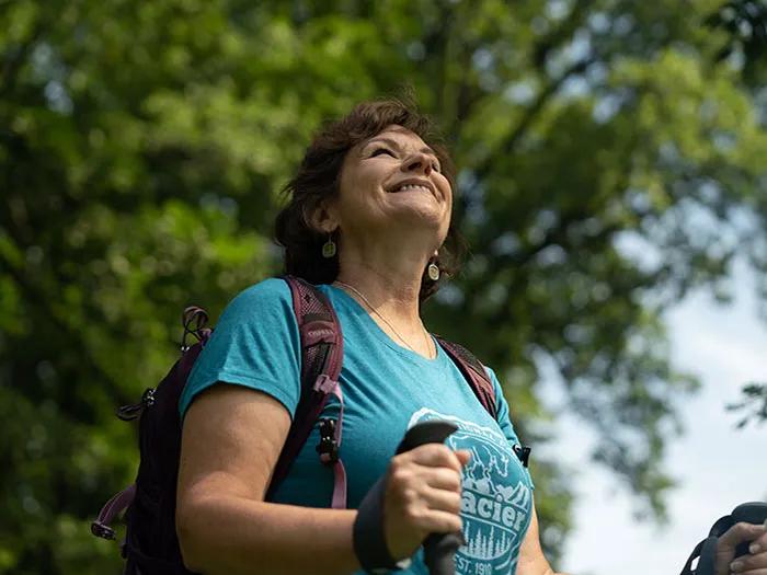 Older woman smiling as she looks up while on a hike