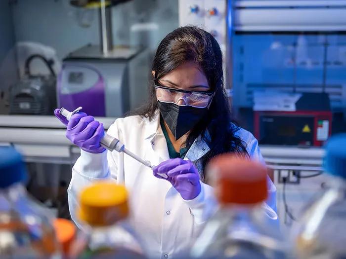 Young Asian woman using a pipette in a laboratory