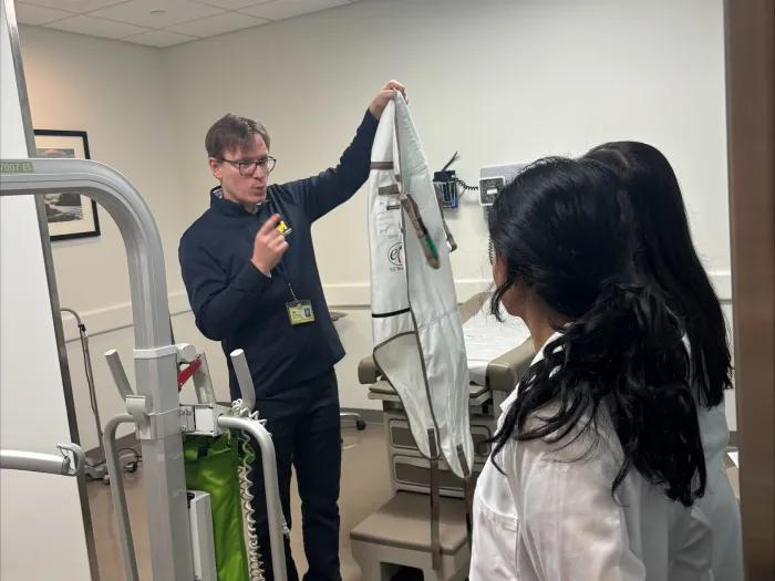 White male doctor shows equipment to medical students in the clinic