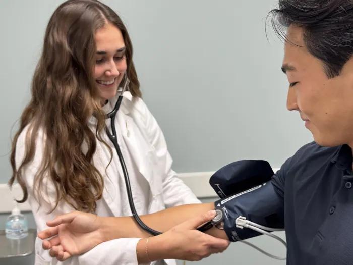 A medical student takes a blood pressure reading on a standardized patient