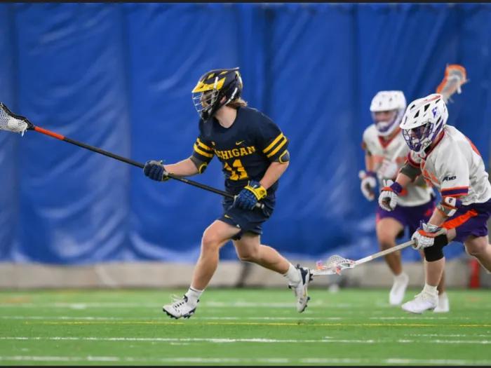 lacrosse player UM playing on field in action