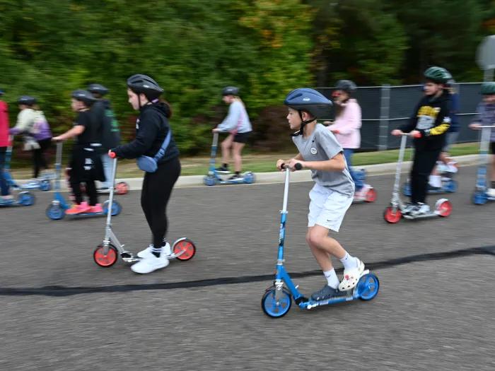 Kids ride scooters