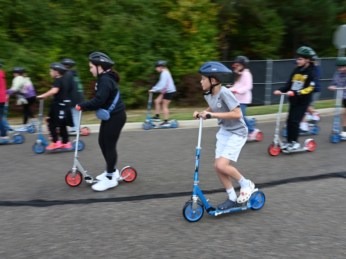 Kids ride scooters