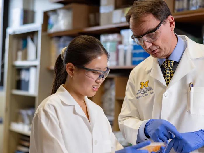 Dr. Kretzler and lab member looking at a sample in the lab