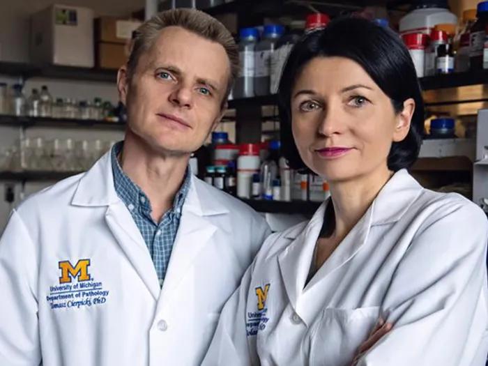 two researchers posing white coats looking at camera