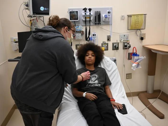 A PA listens to a patients heart