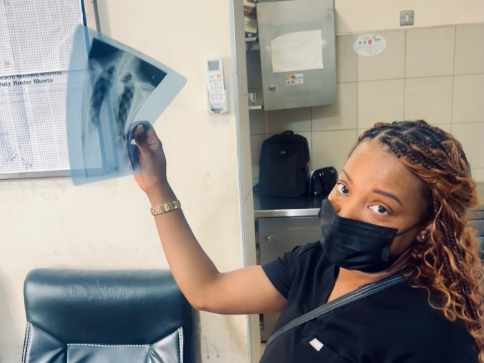 Dr. Marrow holds an x-ray of lungs up to the light.