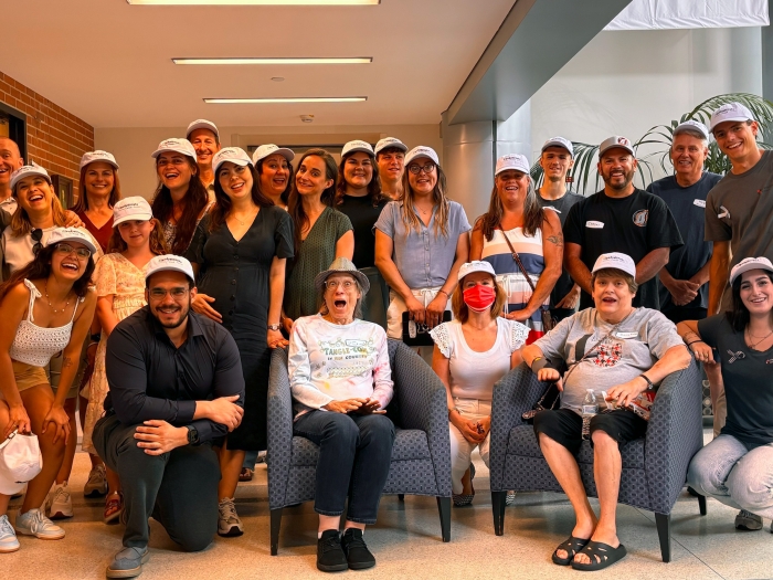 group of people smiling and posing with white hat