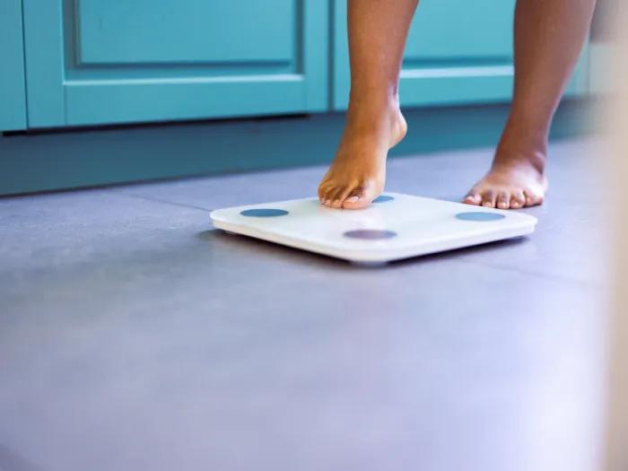 person stepping one foot on scale