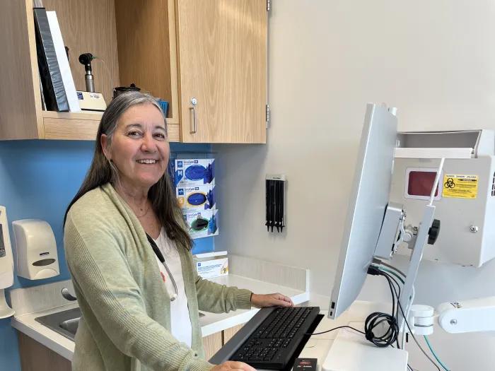 woman standing at a computer in a patient exam room