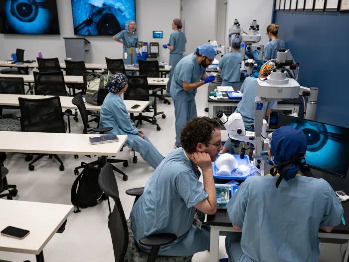 Ophthalmology residents practice surgical skills at microscopes in the wet lab.