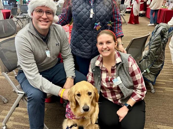 Kyle, Kathy, Alyssa Cozad with a therapy dog on Santa Day