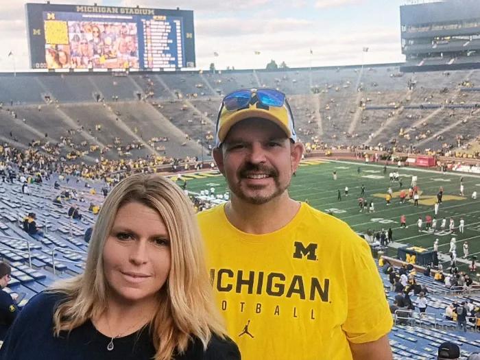 couple smiling at michigan game