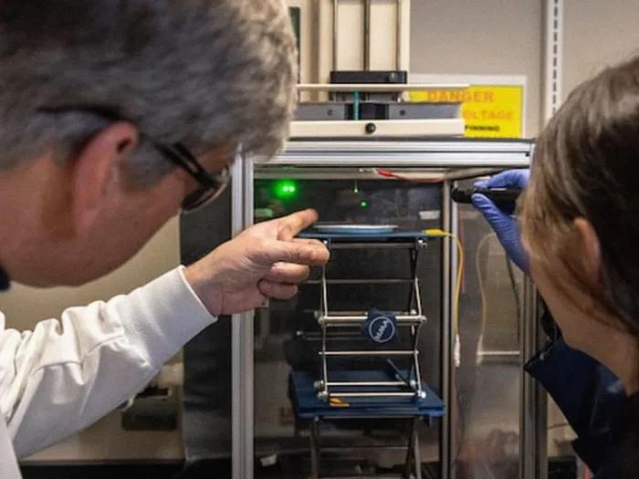 researchers pointing to technical equipment 