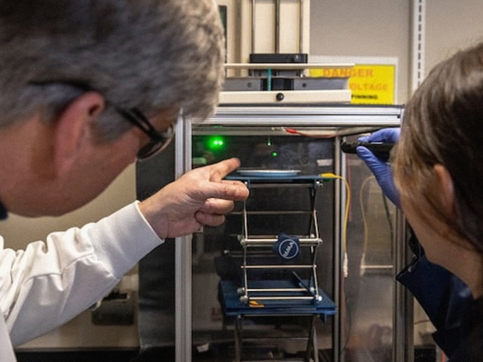 researchers pointing to technical equipment 
