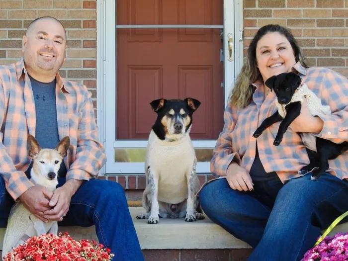 couple with 3 dogs on porch smiling