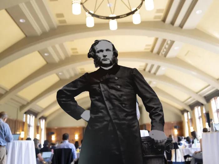 Black and white cutout of Moses Gunn in a conference ballroom.