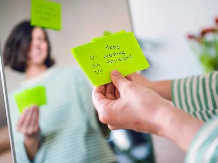 A women standing in front of the mirror with Post-its