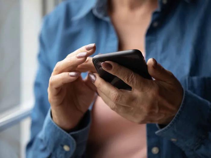 An older adult's hands holding a smartphone