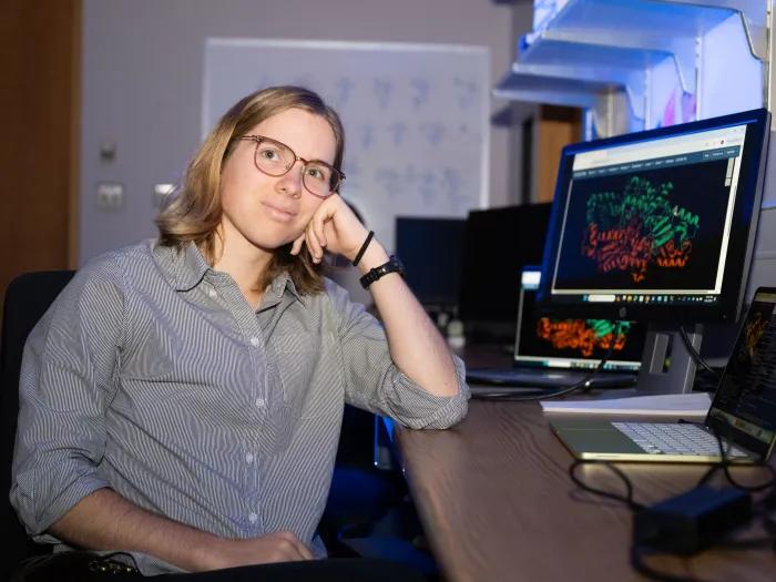 scientist by computer screen displaying a protein structure