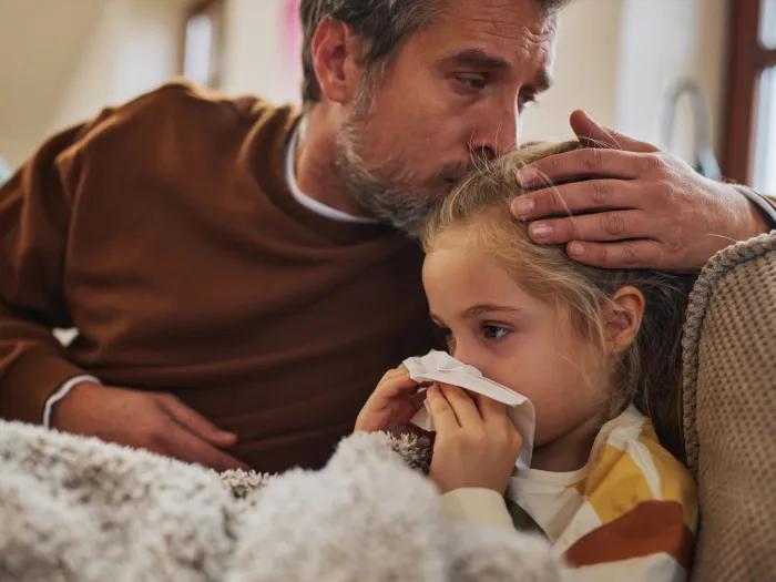 Father comforts sick child