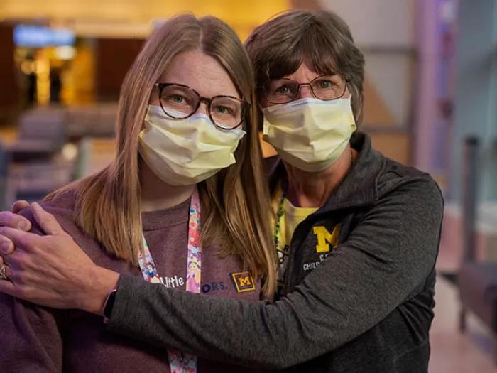 Mother and daughter nurses hugging in room at Mott.