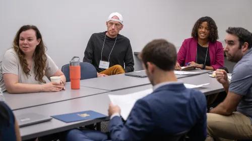 People sitting at a table and talking in a classroom