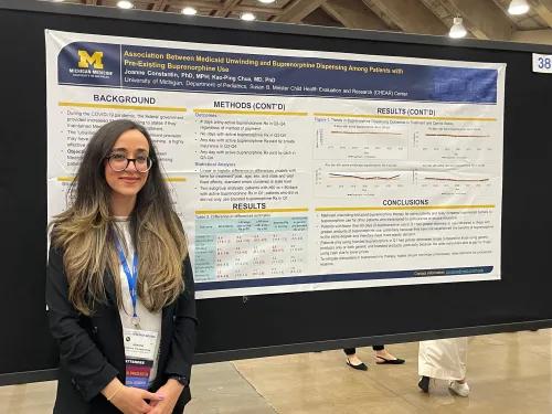 Joanne standing in front of a research poster she created