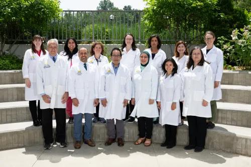 The Pediatric Pulmonary team standing outside on a set of stairs