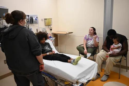 A PA, patient and family members talk in a fast track room