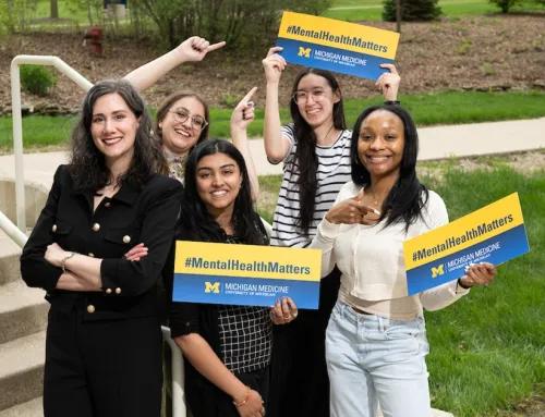 A group pf people holding "mental health matters" signs and smiling