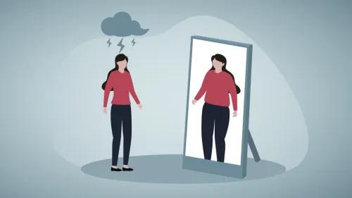 A woman looking into a mirror and seeing a larger body type that she actually has