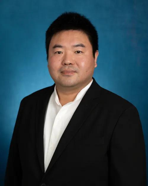 Professional portrait in front of a blue backdrop
