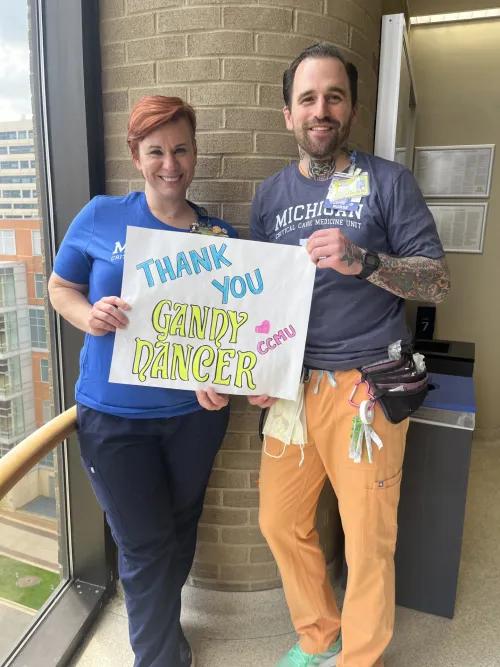 Nurses Corey and Keith with a thank you Gandy Dancer sign for 3 Wishes Program